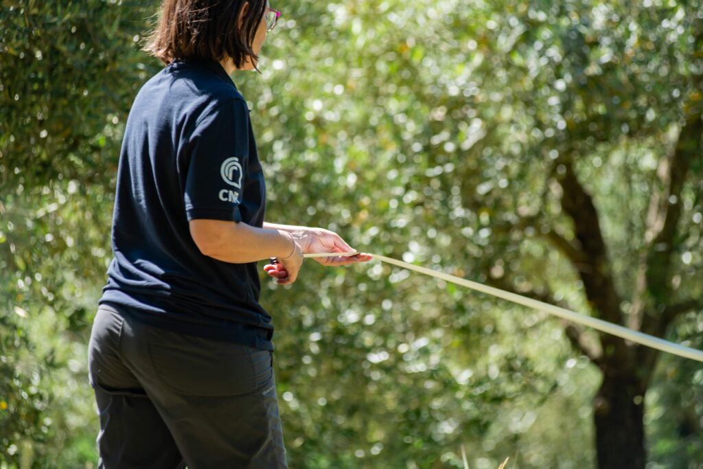 ricercatrice con fettuccia per misurazione campo