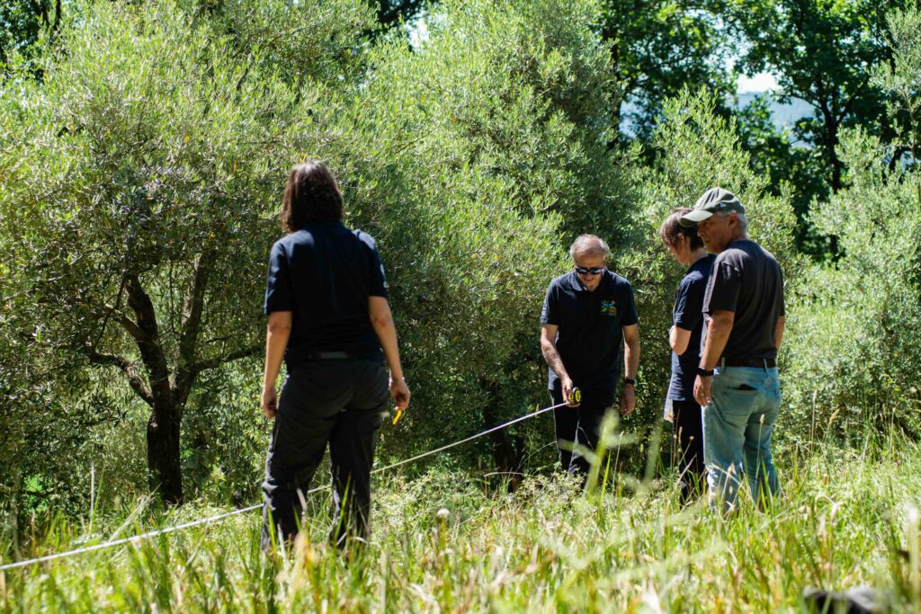 ricercatori con fettuccia per misurazione campo